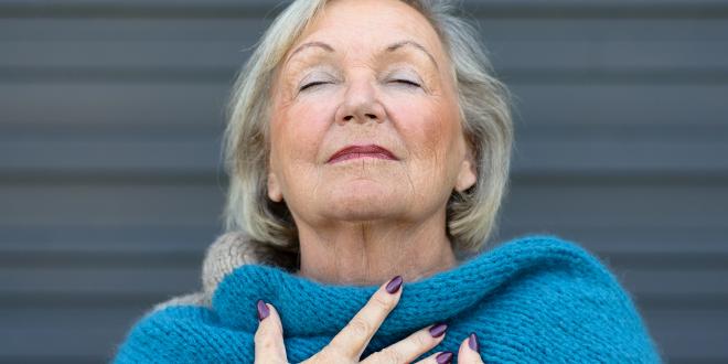 an older woman taking a deep, clear breath
