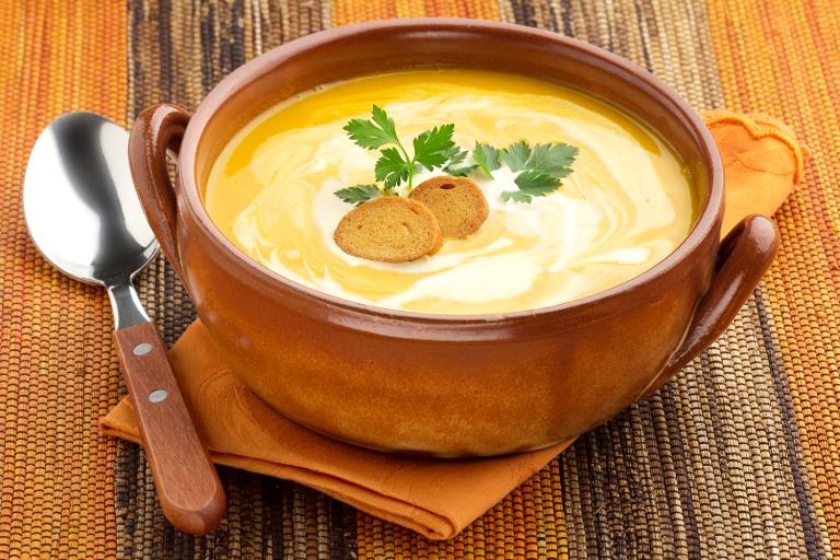 a bowl of carrot soup with a dollop of yogurt